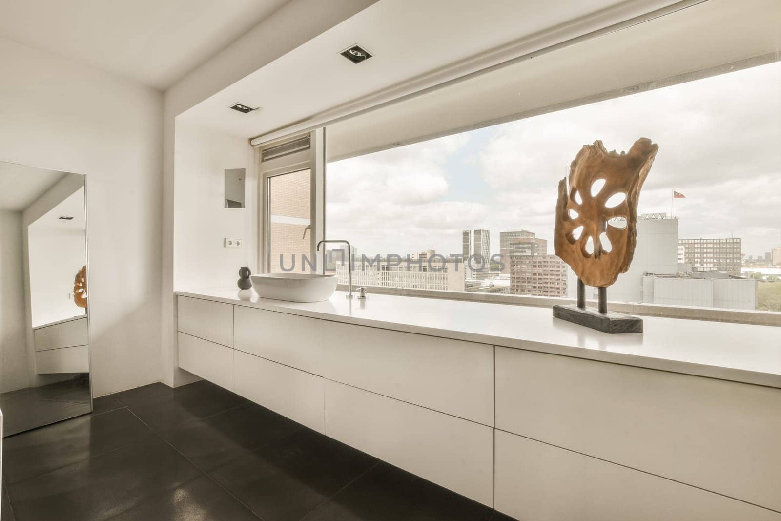 a white bathroom with a large window and a sink by casamedia