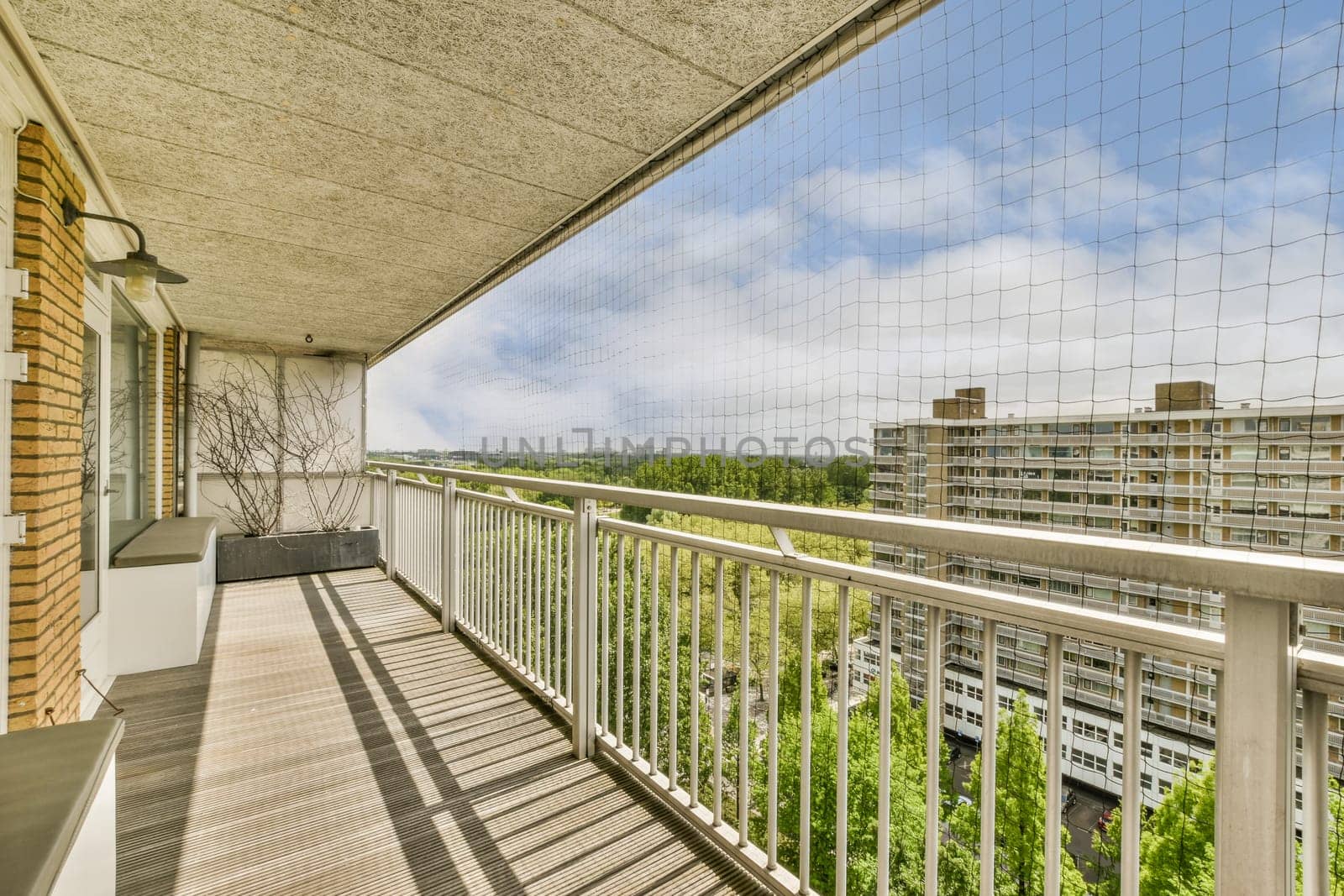 a balcony with a view of the city and trees by casamedia