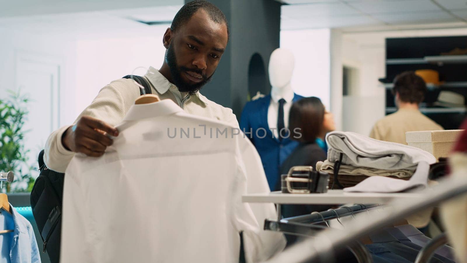 African american client analyzing clothes and accessories by DCStudio