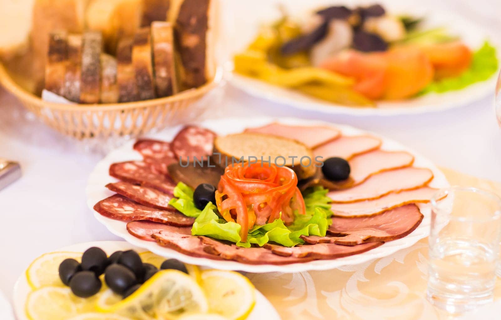 platter of sliced ham,salami and cured meat with vegetable decoration on festive table.
