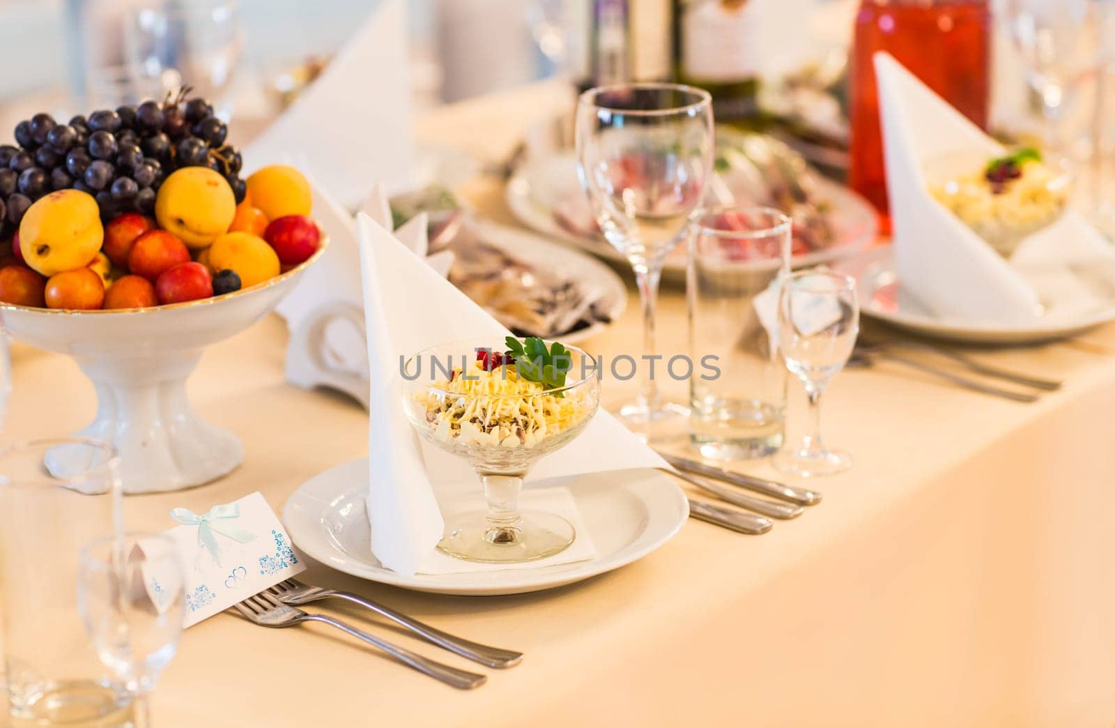 Served for a banquet table. Wine glasses with napkins, plate and salads