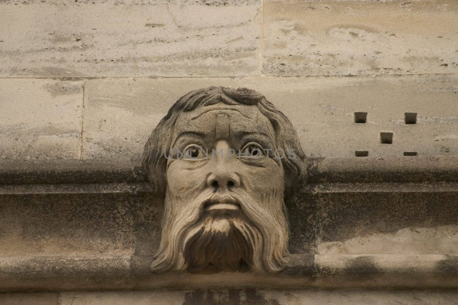 A gargoyle or grotesque sculptures on historic university buildings in Oxford, UK.