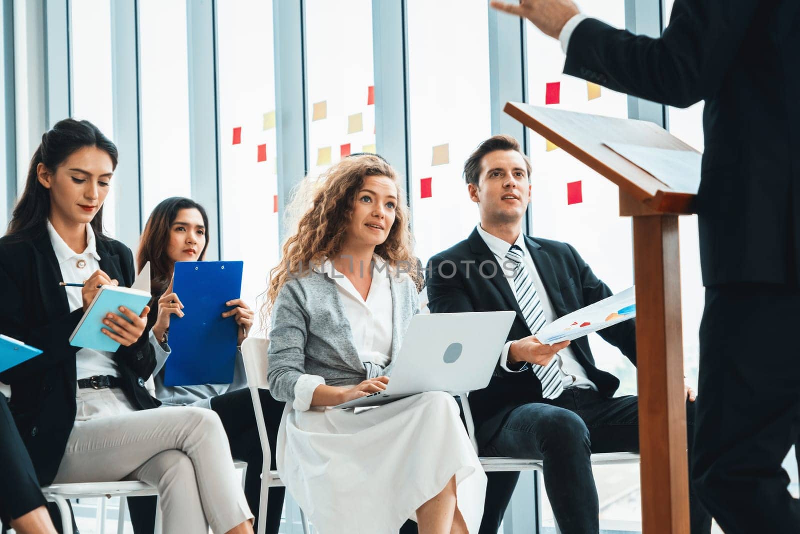 Group of business people meeting in a seminar conference . Audience listening to instructor in employee education training session . Office worker community summit forum with expert speaker . Jivy