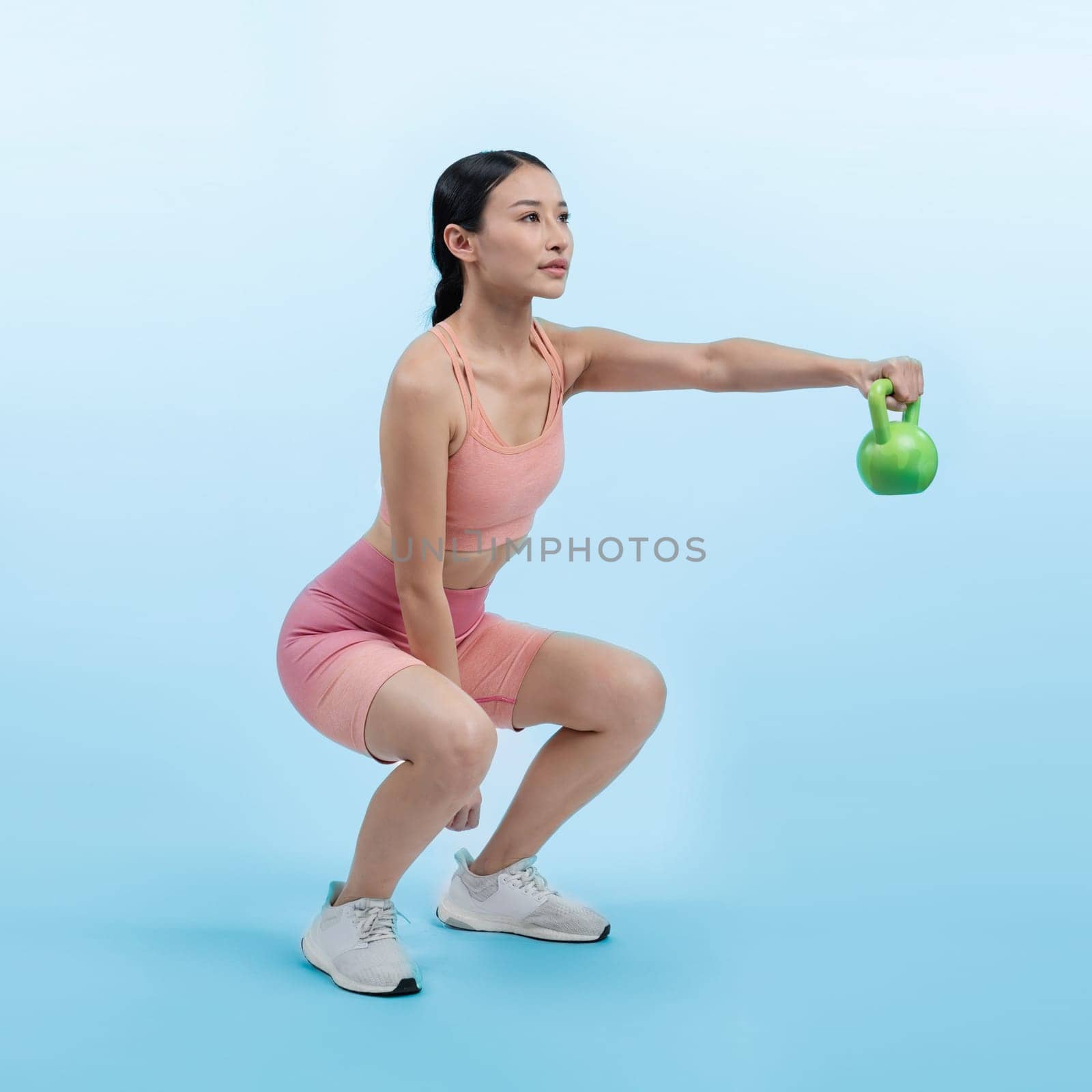 Vigorous energetic woman doing yoga with kettlebell weight exercise. by biancoblue