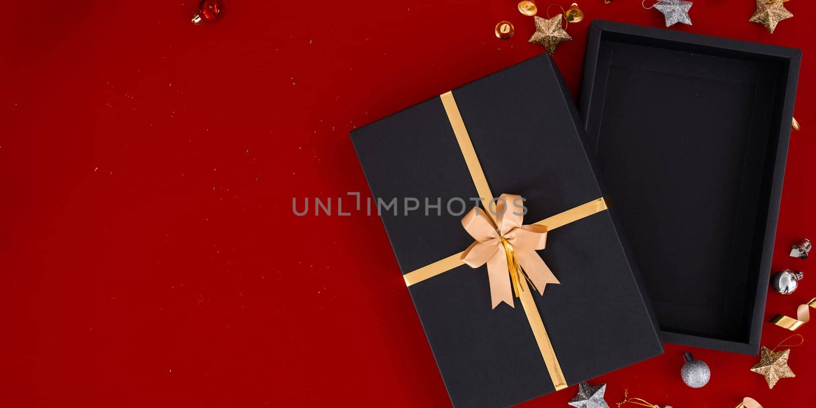 Top view photo of black gift boxes with golden ribbon bow tag and empty open gift box by itchaznong