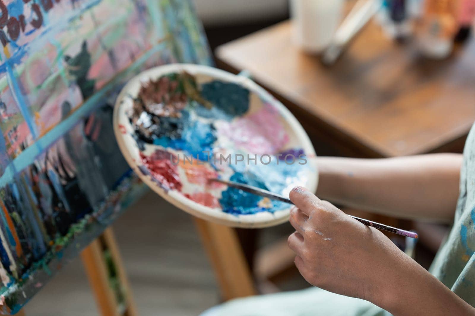 Female artist hold color palette and paintbrush for painting during hobby workshop by itchaznong