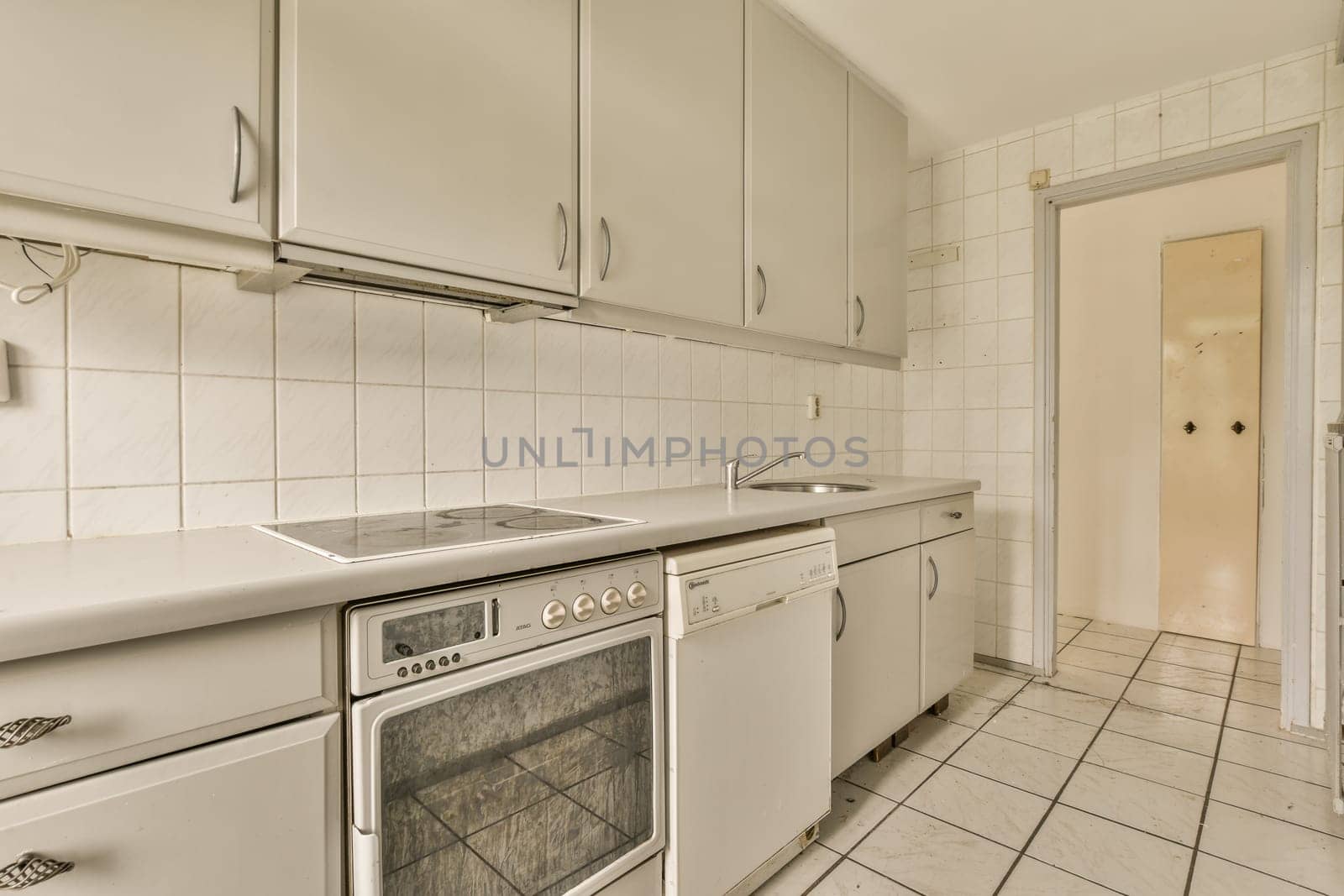 a kitchen with white cabinets and a stove and sink by casamedia