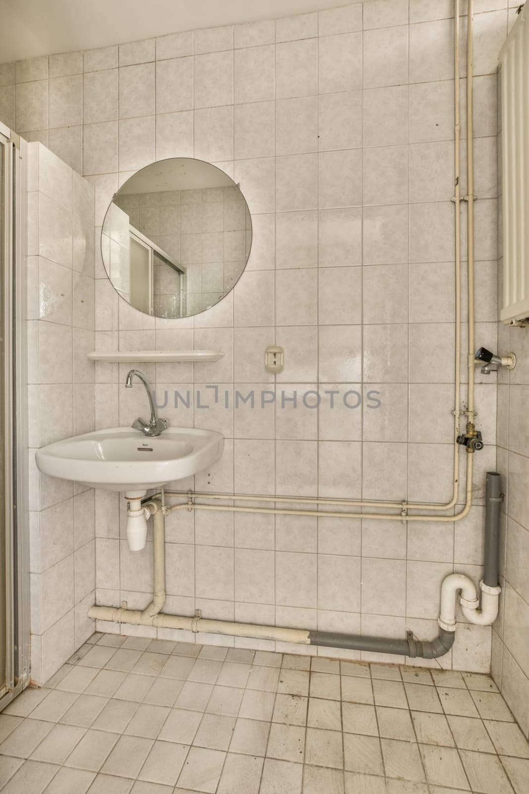 a bathroom with a sink, mirror and toilet roll on the wall next to it is a white tiled floor