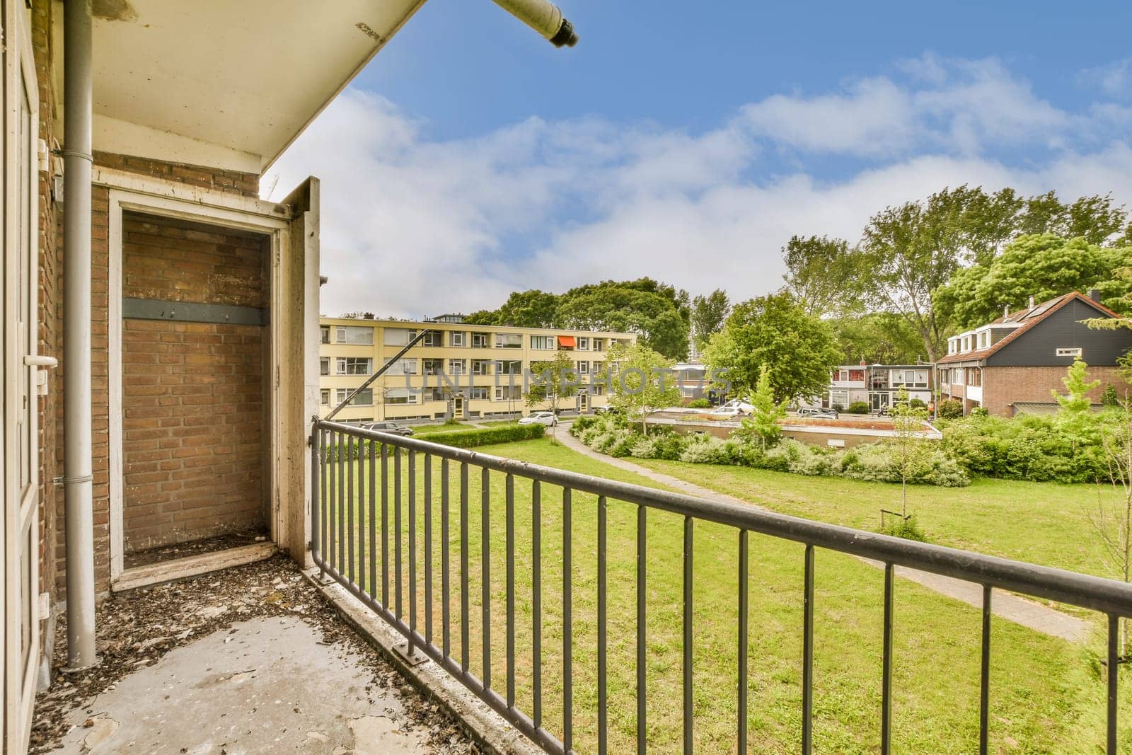 an outside area with some buildings in the background and green grass on the other side of the photo is clear blue sky