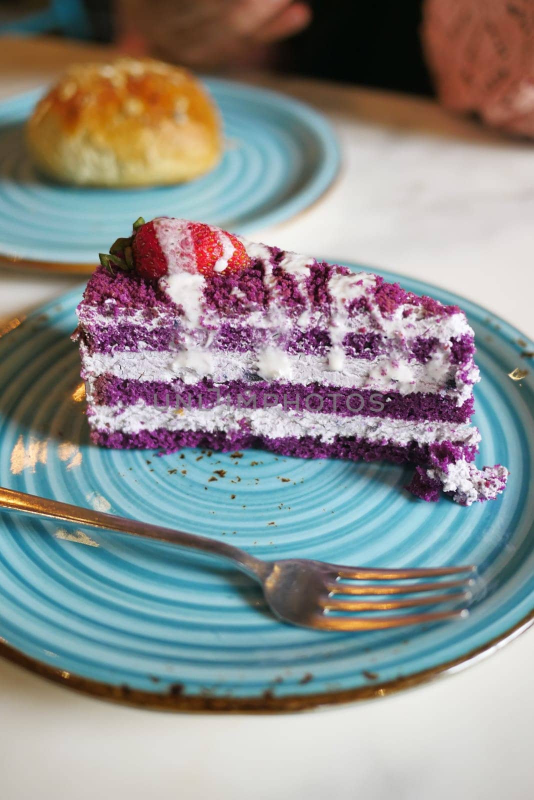 cutting A piece of purple velvet cake with cream .