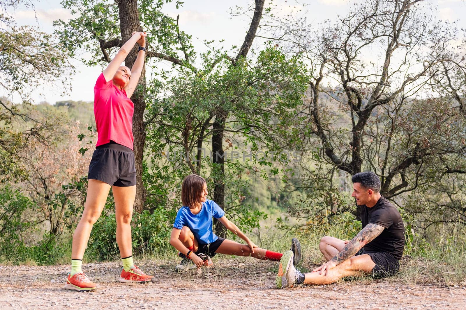 family stretching and warming up for sports in the countryside, concept of sport with kids in nature and active lifestyle, copy space for text