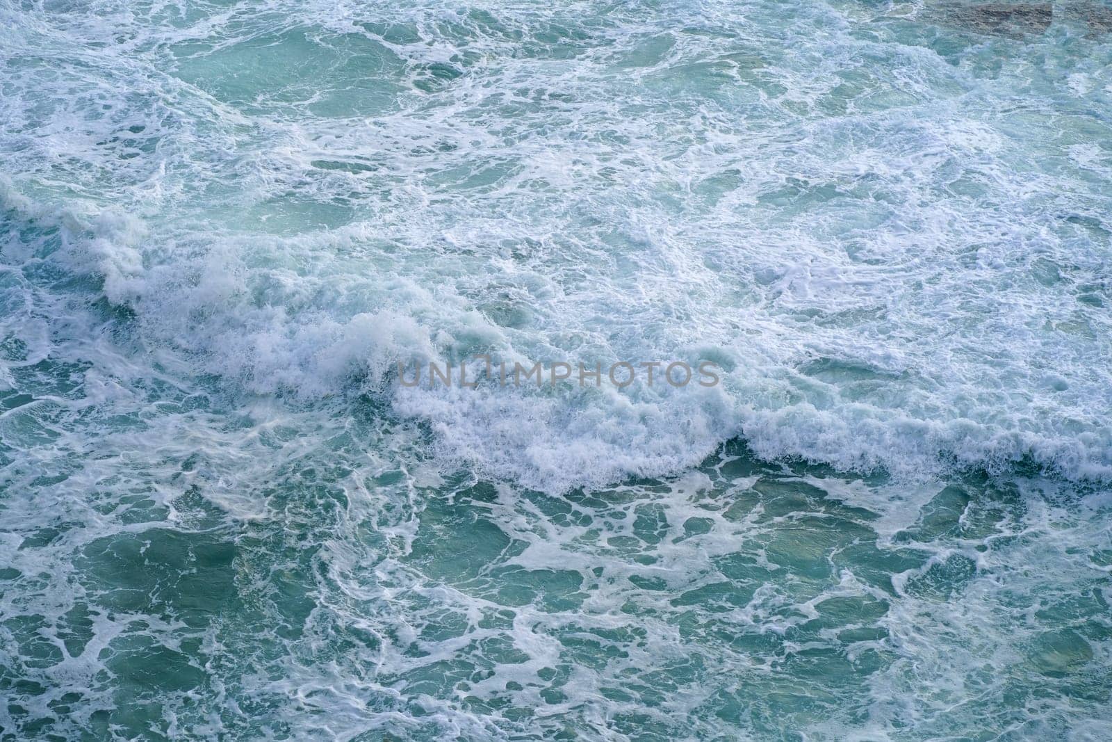 Waves crashing on seashore rocks,Top view sea surface waves background