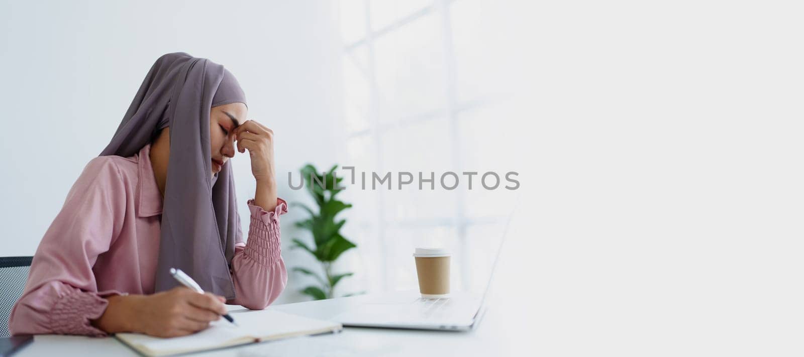 Muslim female employee working in office burnout