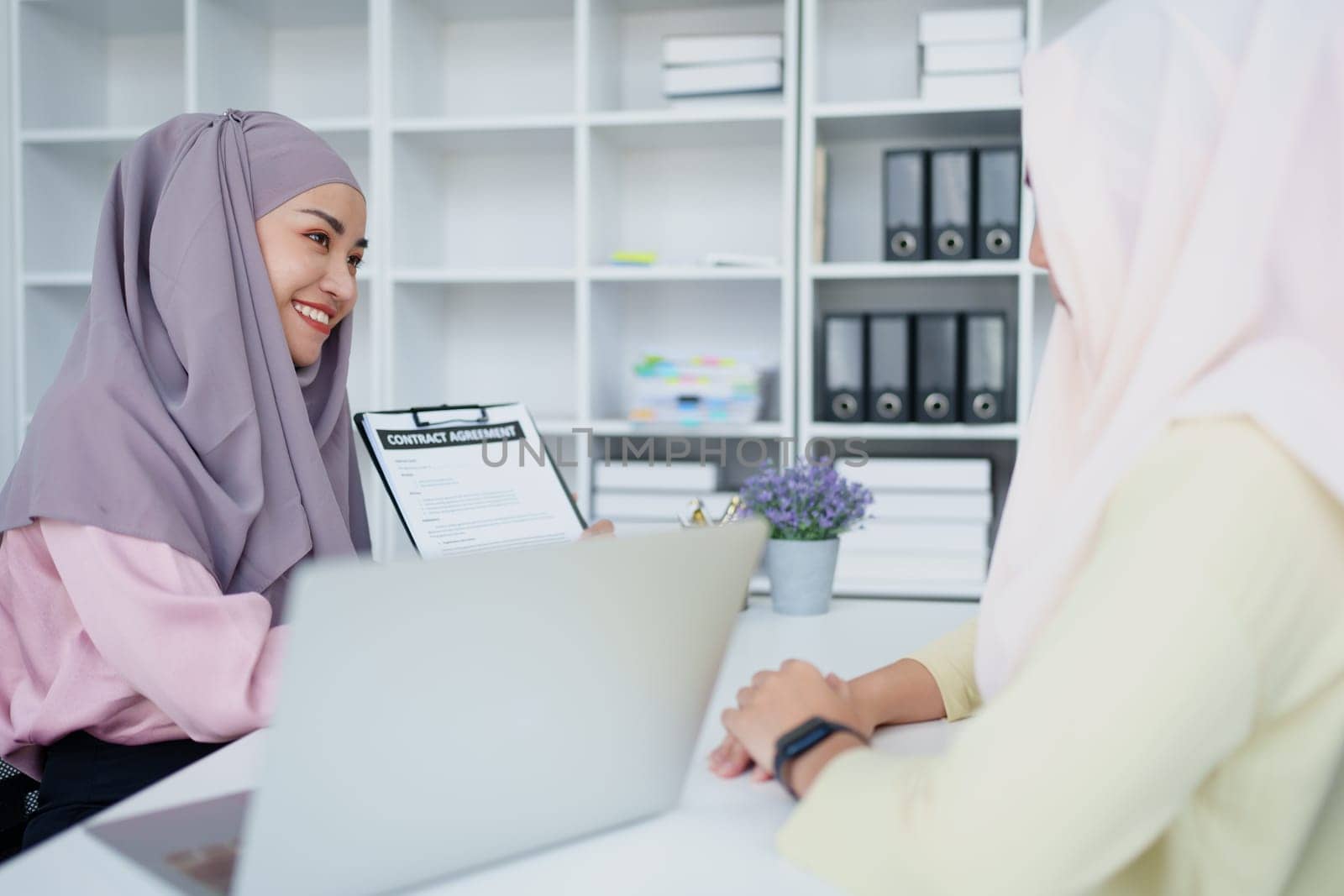 Muslim female employee Hold important documents and discuss agreements with customers