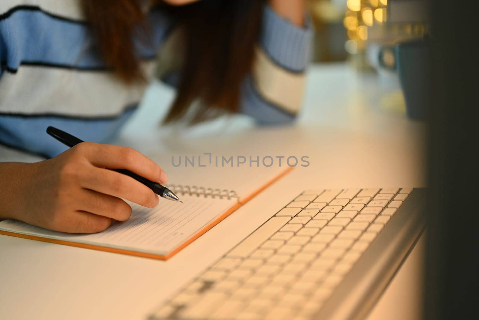 Cropped shot of young woman writing notes in personal daily planner, planning workday.