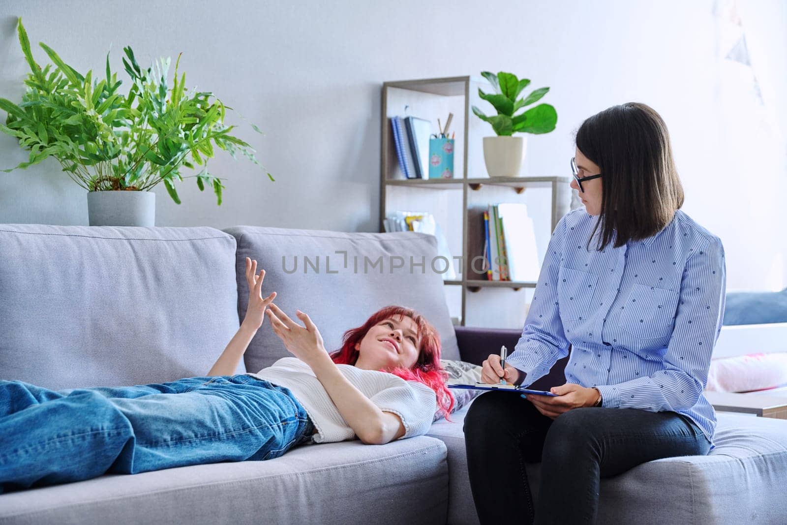 Session therapy of teenage student girl with counseling psychologist. Female teenager lying on couch talking about problem mental health. Adolescence psychology therapy psychotherapy professional help