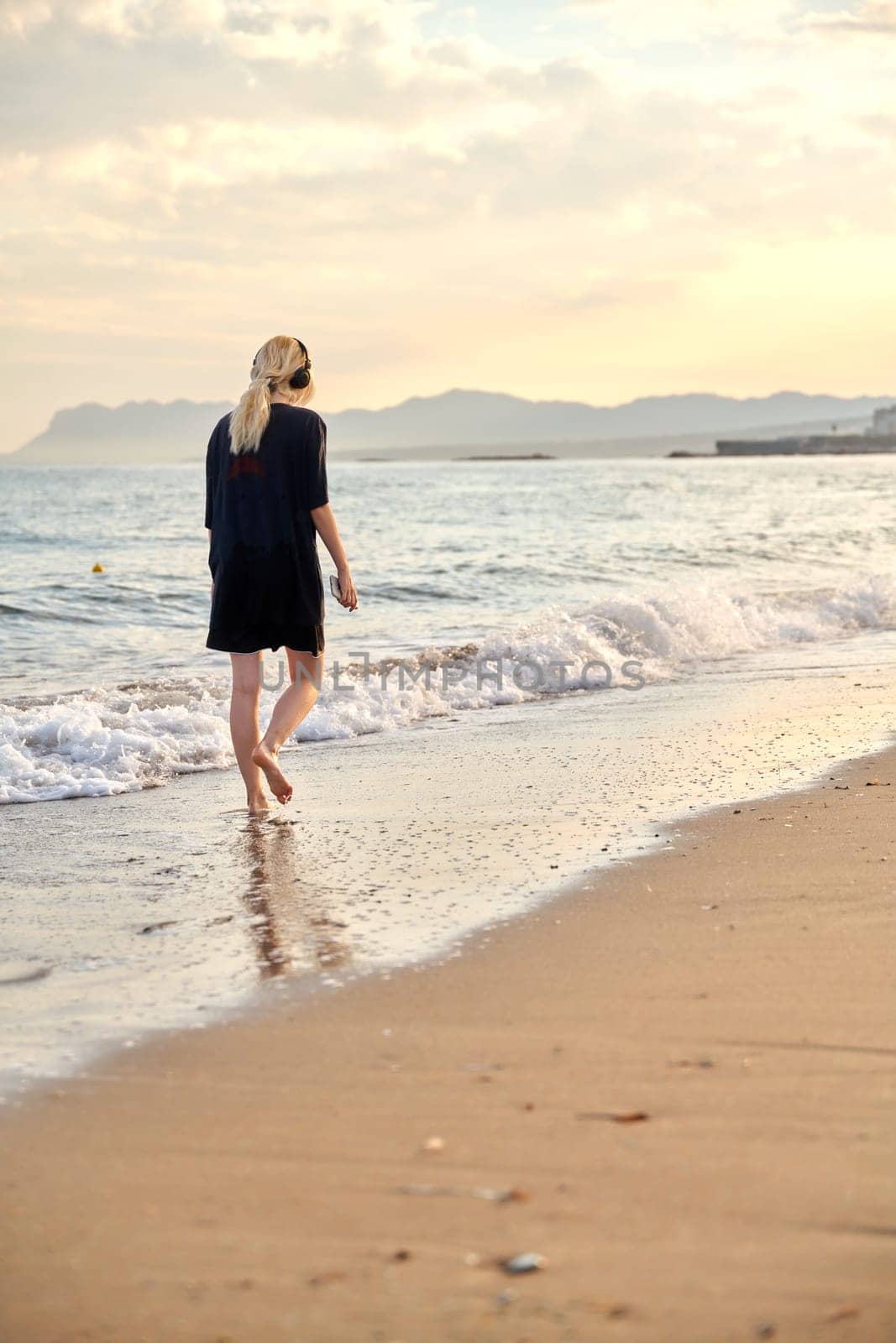 Young teenage female on the beach in the morning by VH-studio