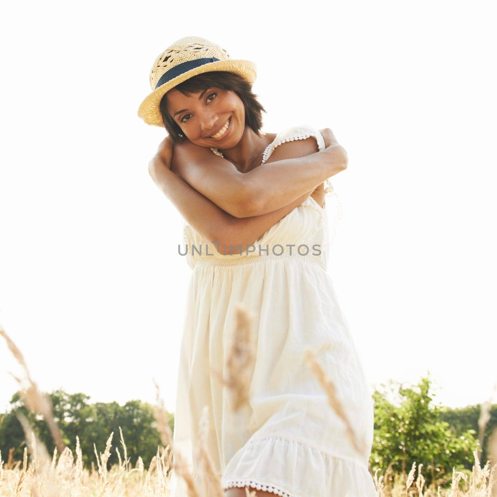 Portrait, field and woman with self love, hug and summer with happiness, sunshine and relax. Person, outdoor and girl with nature, grass and eco friendly with weekend break and embrace with a smile by YuriArcurs