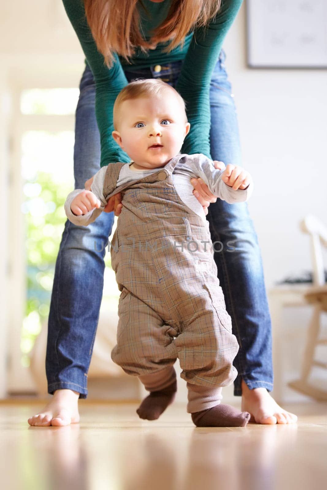 Mother, baby and face with help for walking in home for motor skills, development or milestone with assistance. Son, toddler and excited for mobility, movement or freedom in living room with support.
