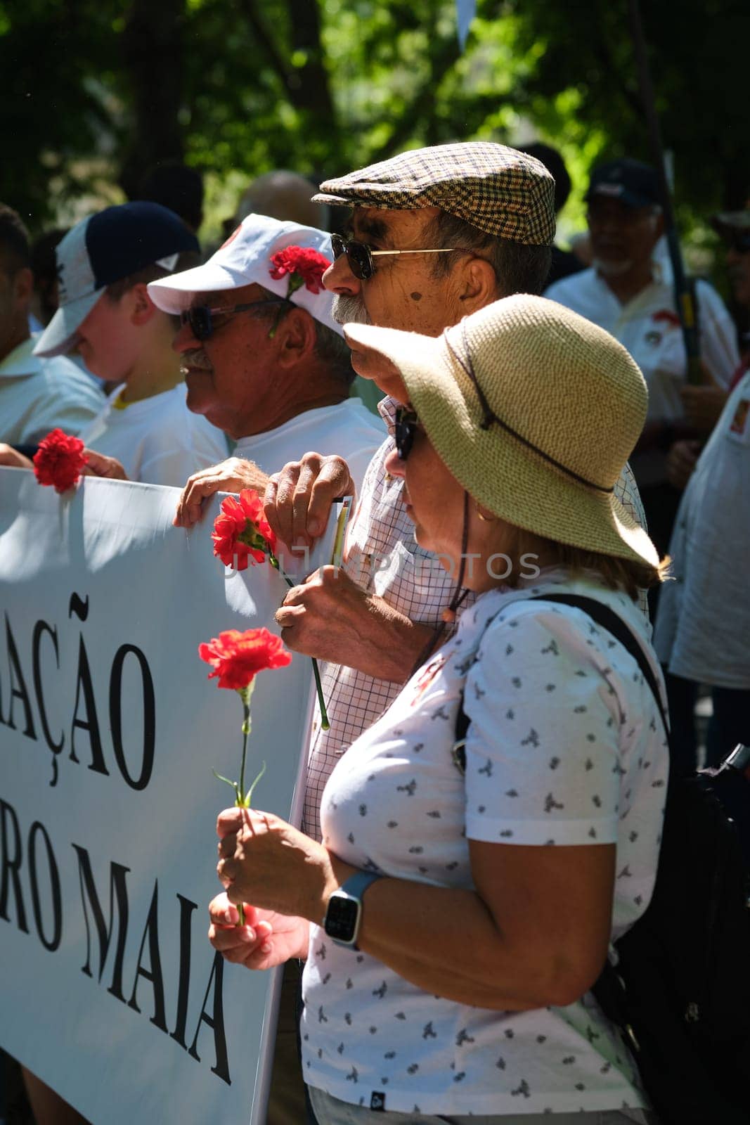 Lisbon, Portugal - April 25, 2023: People with carnations at anniversary celebration of The Carnation Revolution aka the 25 April Revolution (25 de Abril) by demonstration march