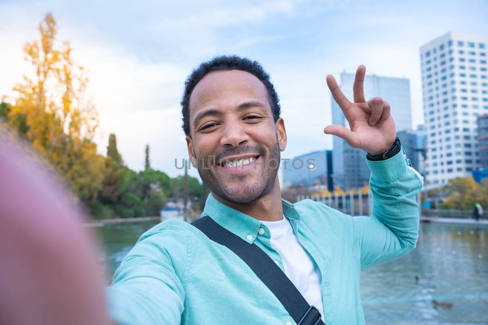 Young African American man taking a selfie looking at camera smiling - Tourist student by PaulCarr