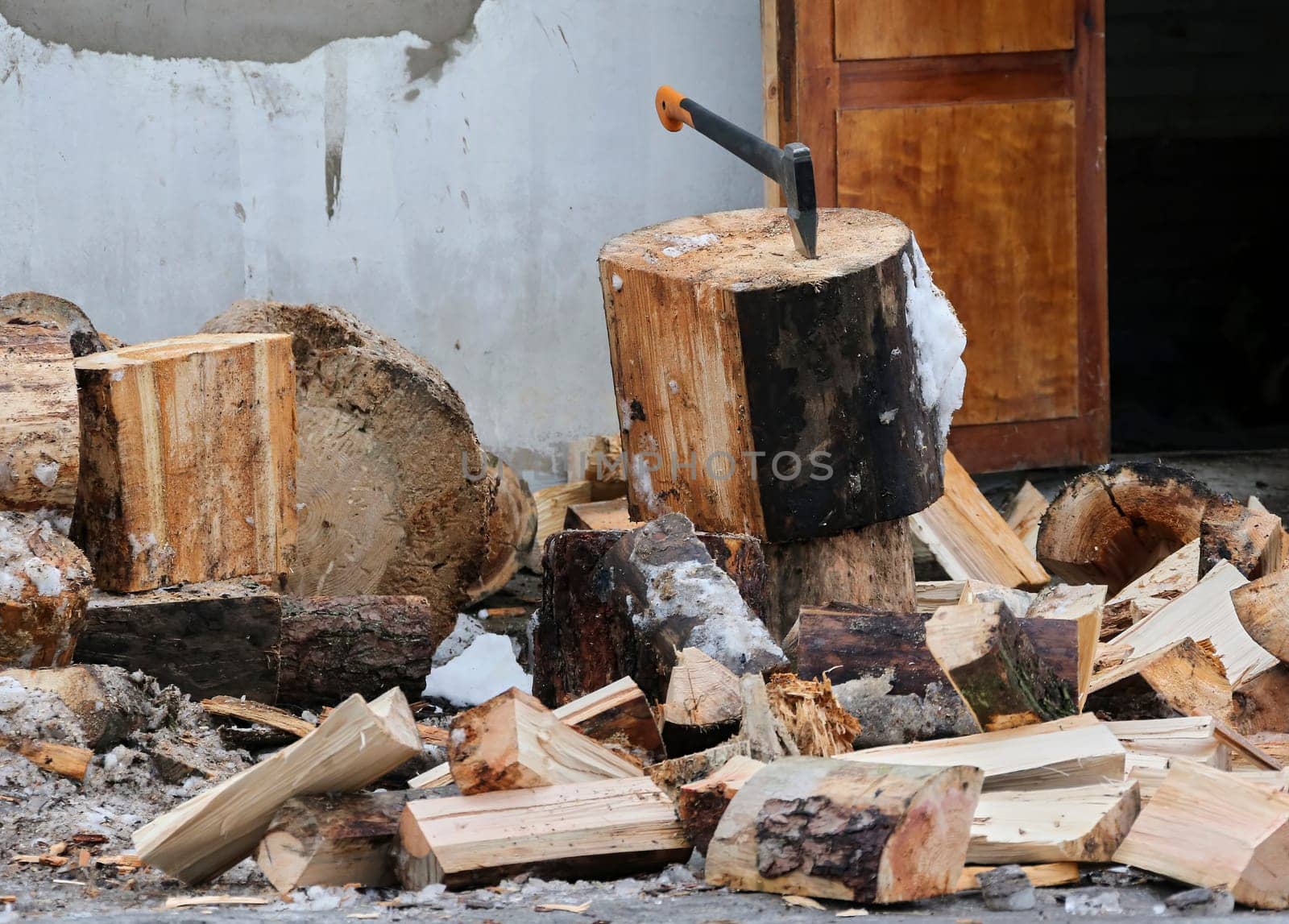 Old ax and a deck for chopping wood. Dry firewood, chopped wood for winter heating of the fireplace.