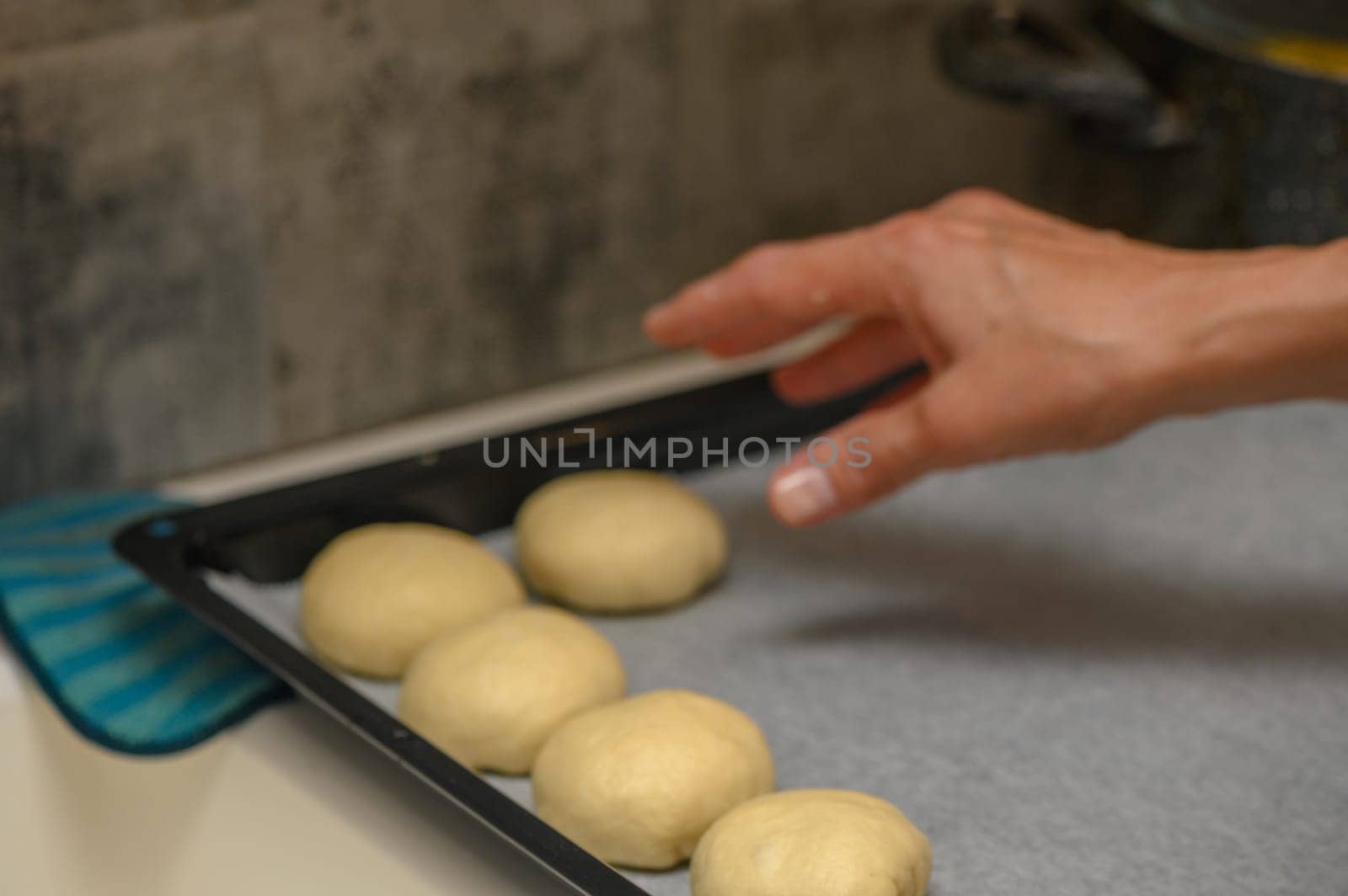 woman placing buns on a baking sheet 1