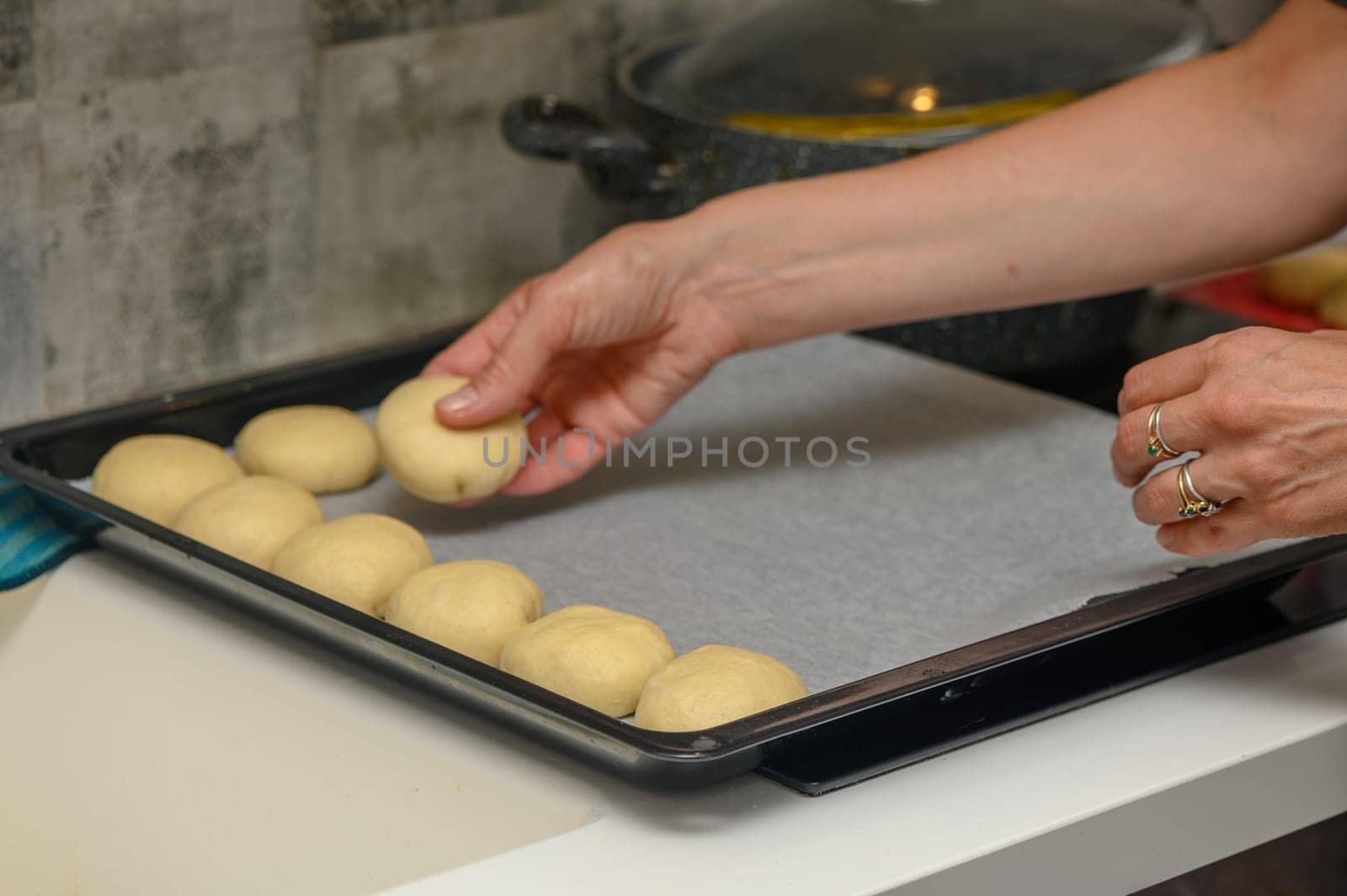 woman placing buns on a baking sheet 6