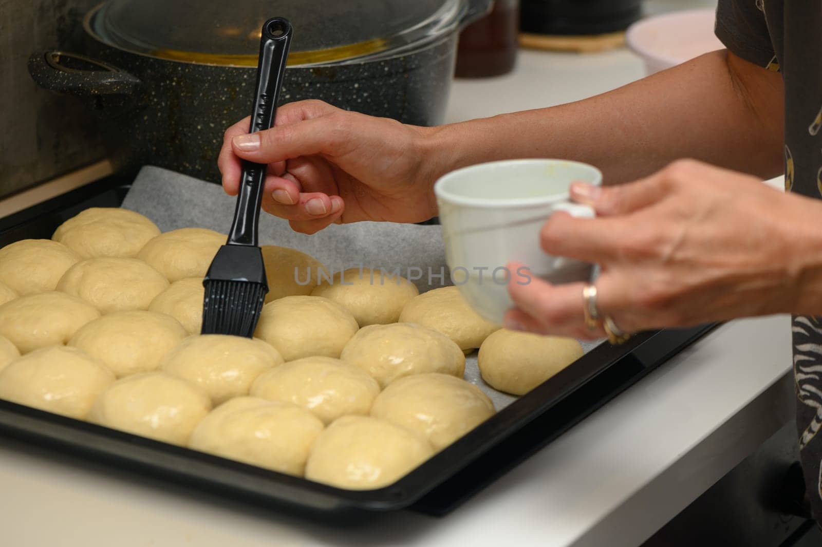 woman greases buns in the kitchen 2