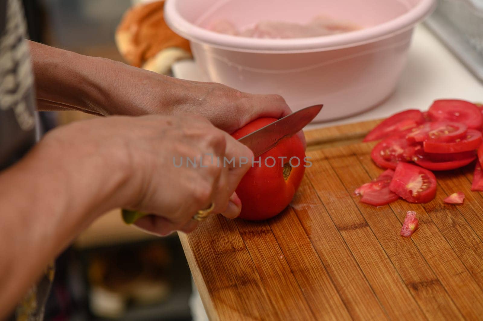 woman cutting tomato on kitchen board 1