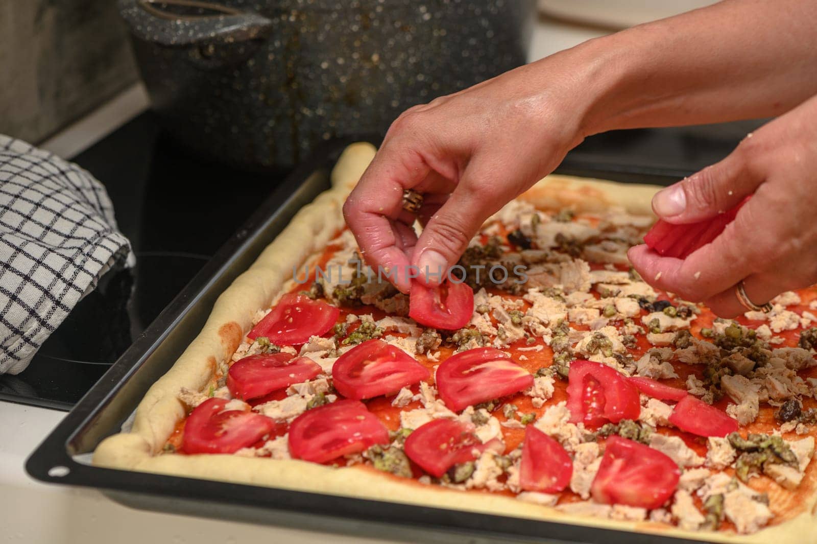 a woman prepares pizza with cheese, tomatoes and chicken ham, a woman lays out tomatoes 5 by Mixa74
