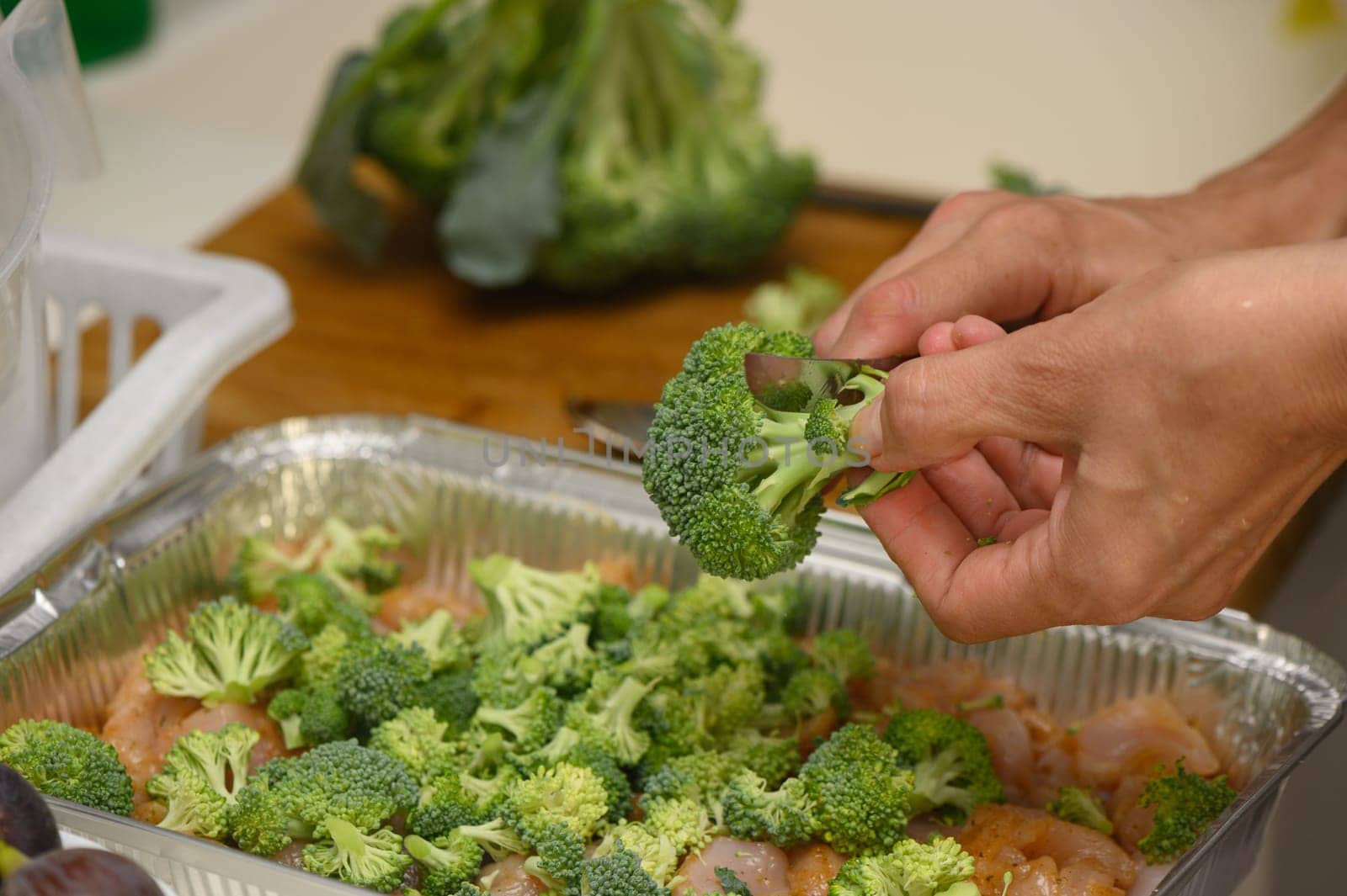 woman cutting broccoli into chicken fillet for baking 9