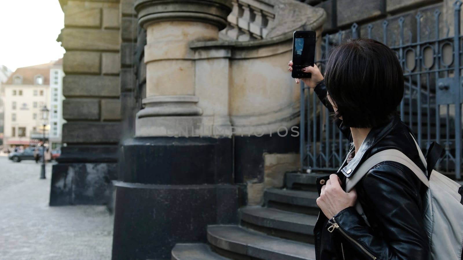 Attractive Woman Strolls Through Touristic Places Of Dresden, Capturing Photos Of Sightseeings