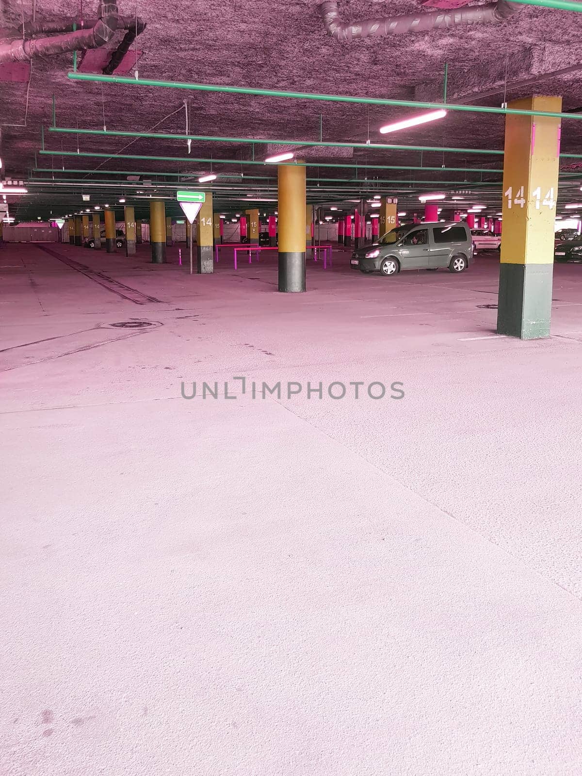 Underground Parking with poles with markings for cars in the shopping center, a place for text at the bottom.