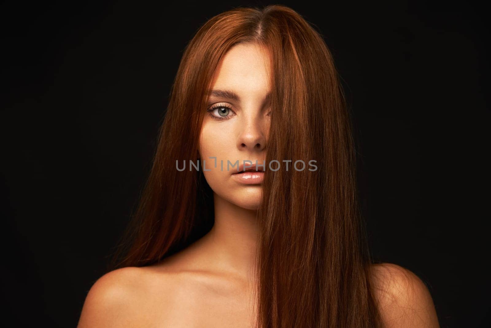 Hair care, portrait or woman with beauty, skincare or results for glow, shine or collagen in studio. Black background, face or serious model with cosmetics for treatment, healthy texture or growth by YuriArcurs
