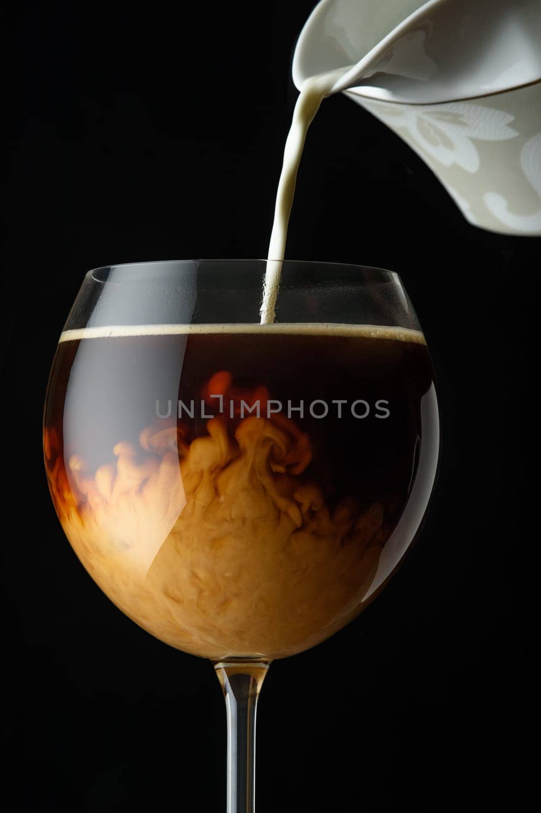 hot aromatic coffee in a wine glass with milk poured into it 1 by Mixa74