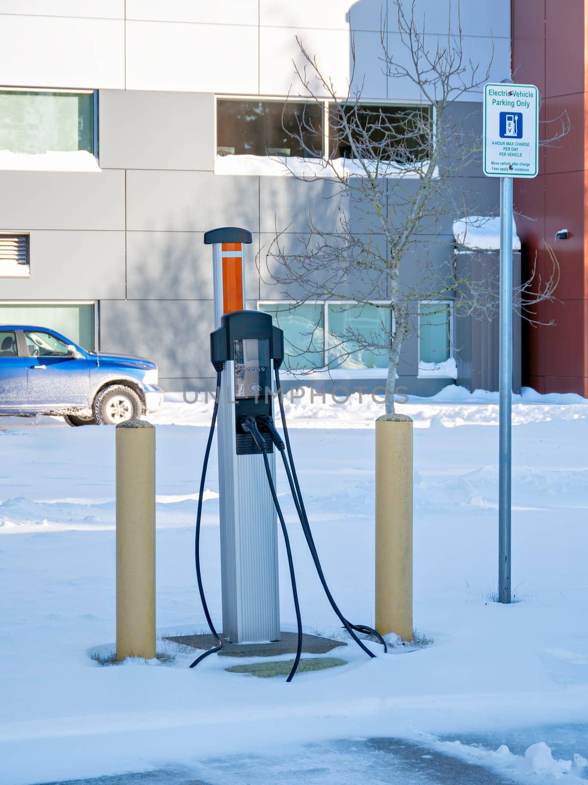 EV charging station on winter season with gas truck parked nearby by Imagenet