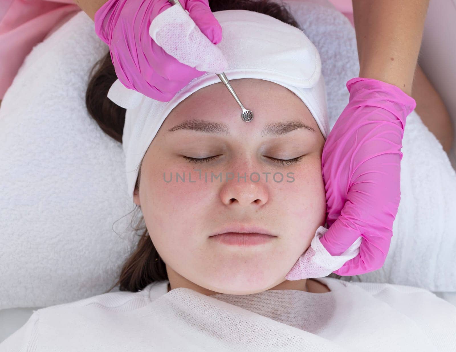 Mechanical Cleansing of Face Skin With Spoon Uno, Removing Grease and Blackheads. Young Plus Size Woman Getting Professional Skin Peeling, Cleaning by Beautician, Aesthetician. Top View, Horizontal. by netatsi