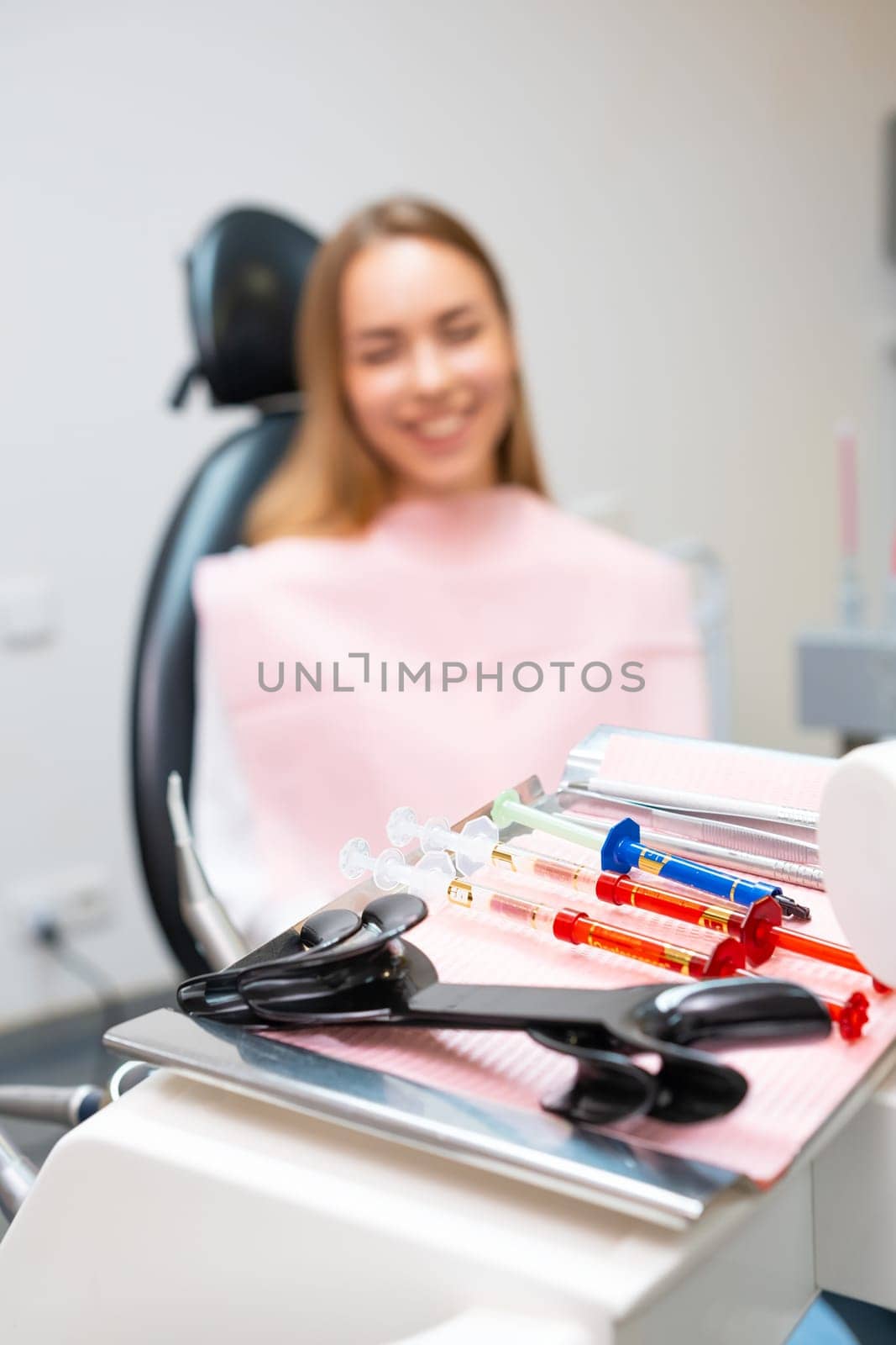 Close up tools for teeth whitening with happy patient on the background in dentist office.