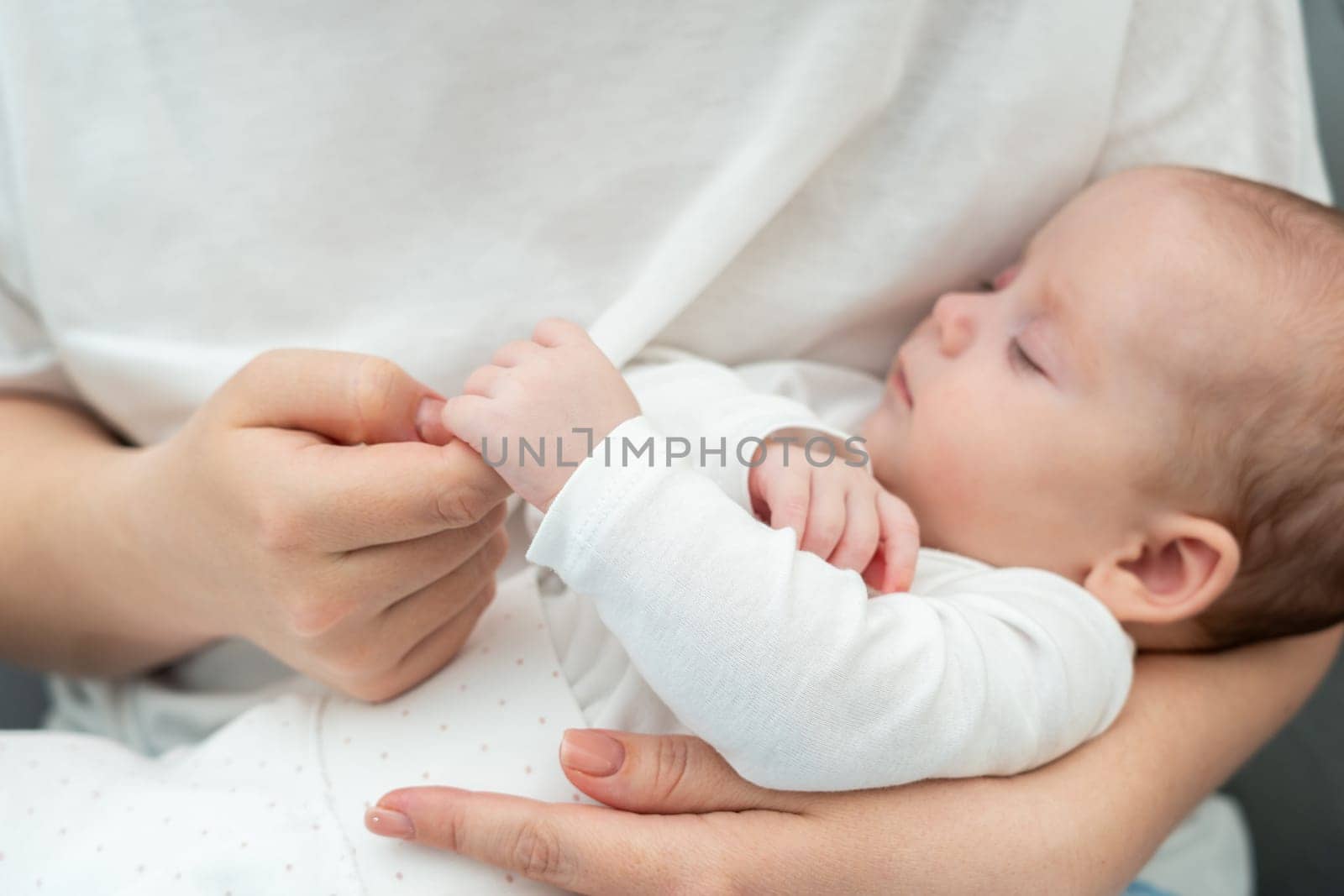 Infant's soft touch clasping mother's finger speaks volumes. Concept of pure mother-child connection by Mariakray