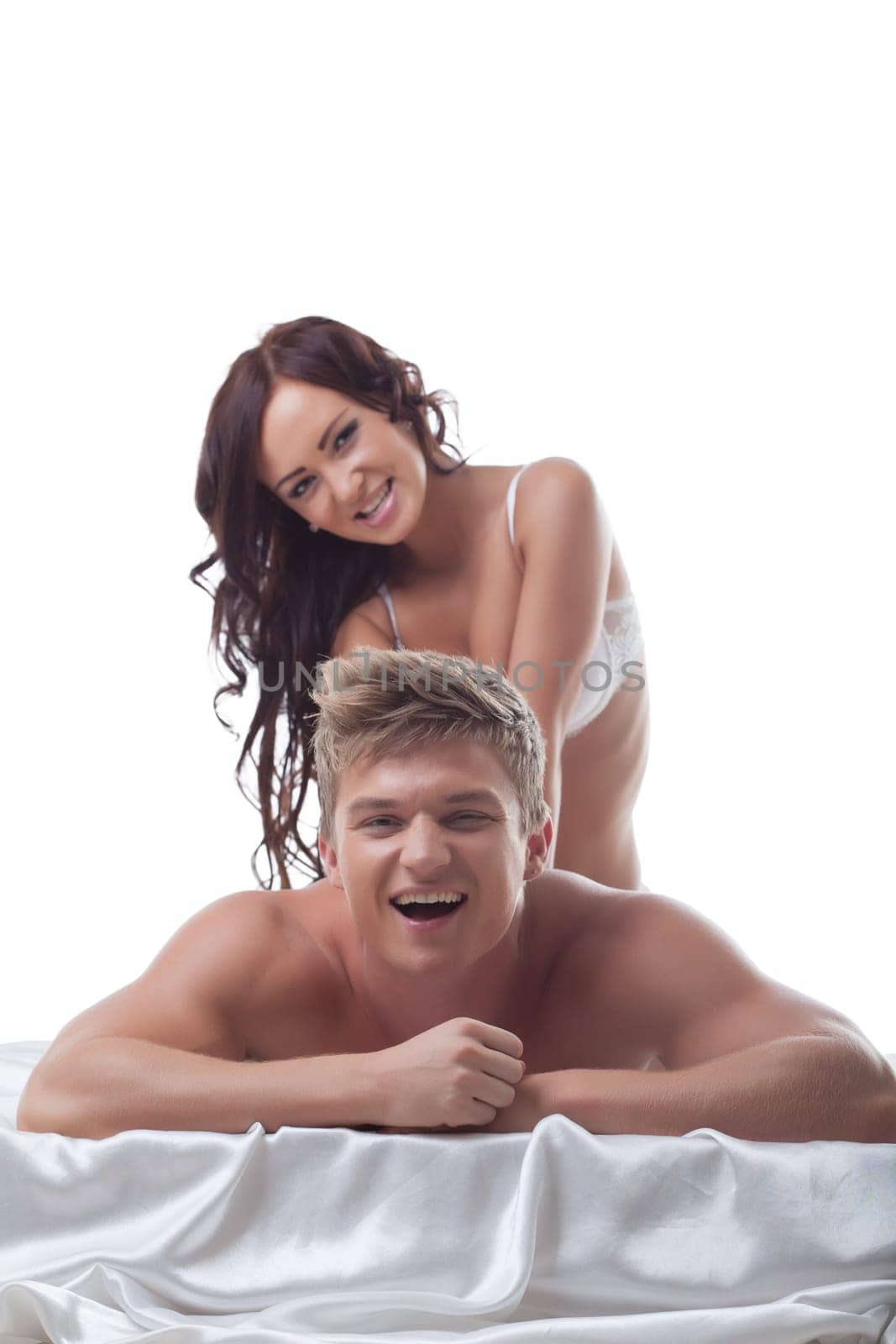 Grinning girl doing massage to her lover and he laughs