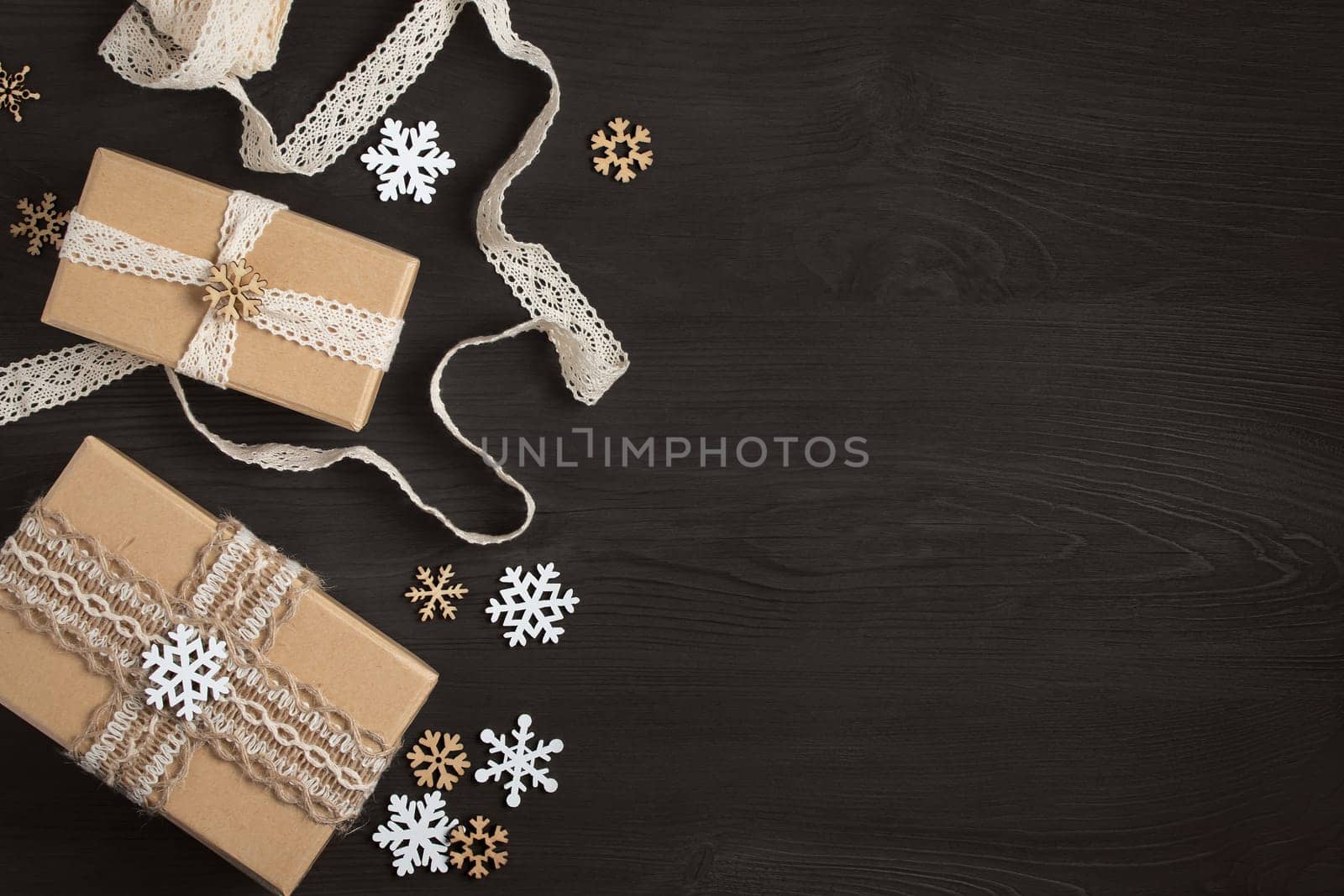 Christmas gifts and decorations made of natural materials on a dark wooden table with a copy of the space. Mockup for cards and advertisements by galsand