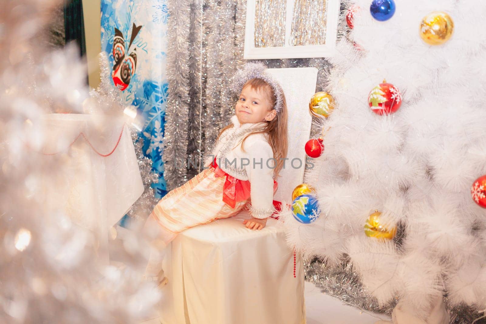 Girl in a New Year's dress near the Christmas tree. High quality photo