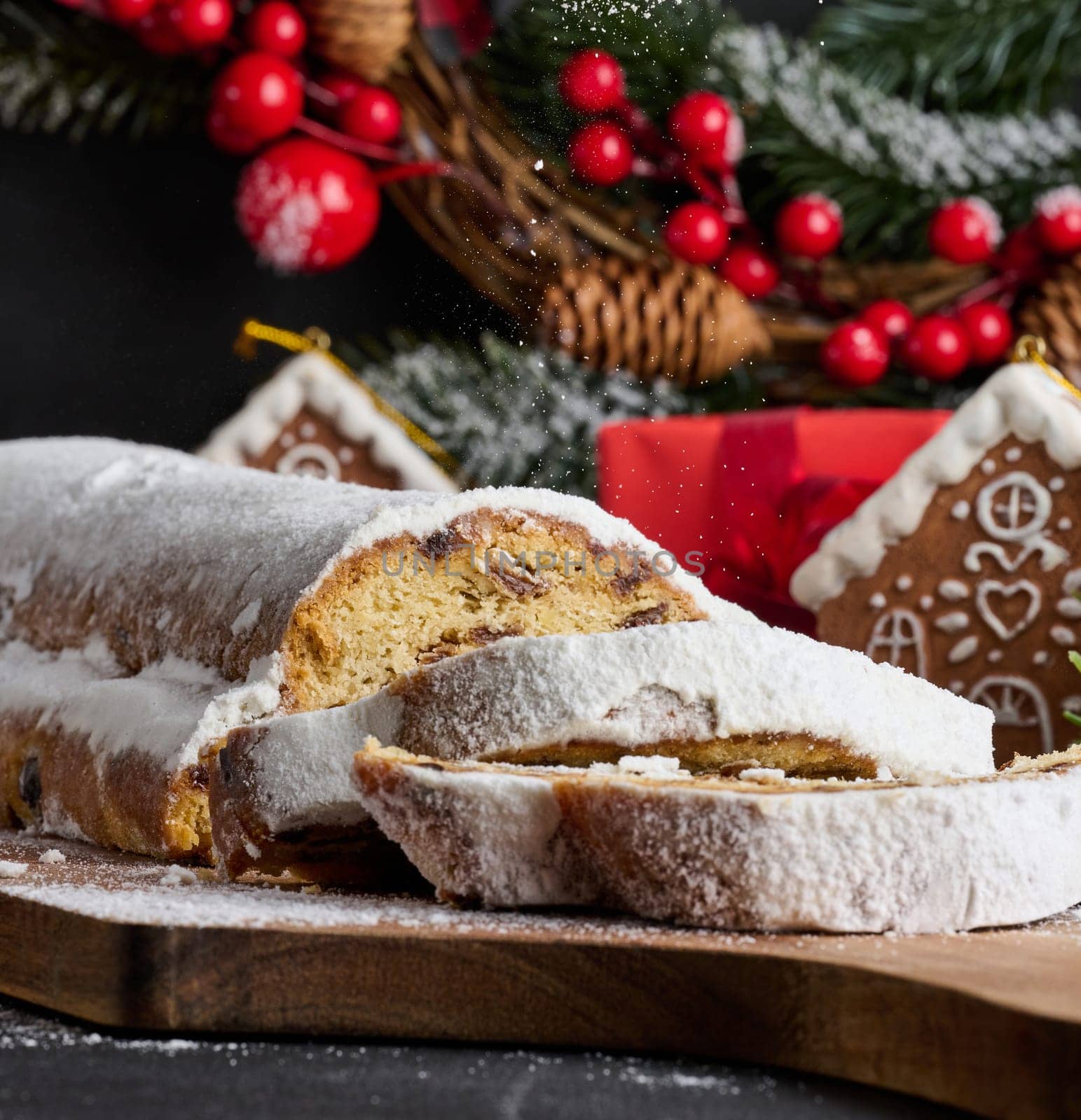 Christmas pastries stollen sprinkled with powdered sugar on the table, festive dessert