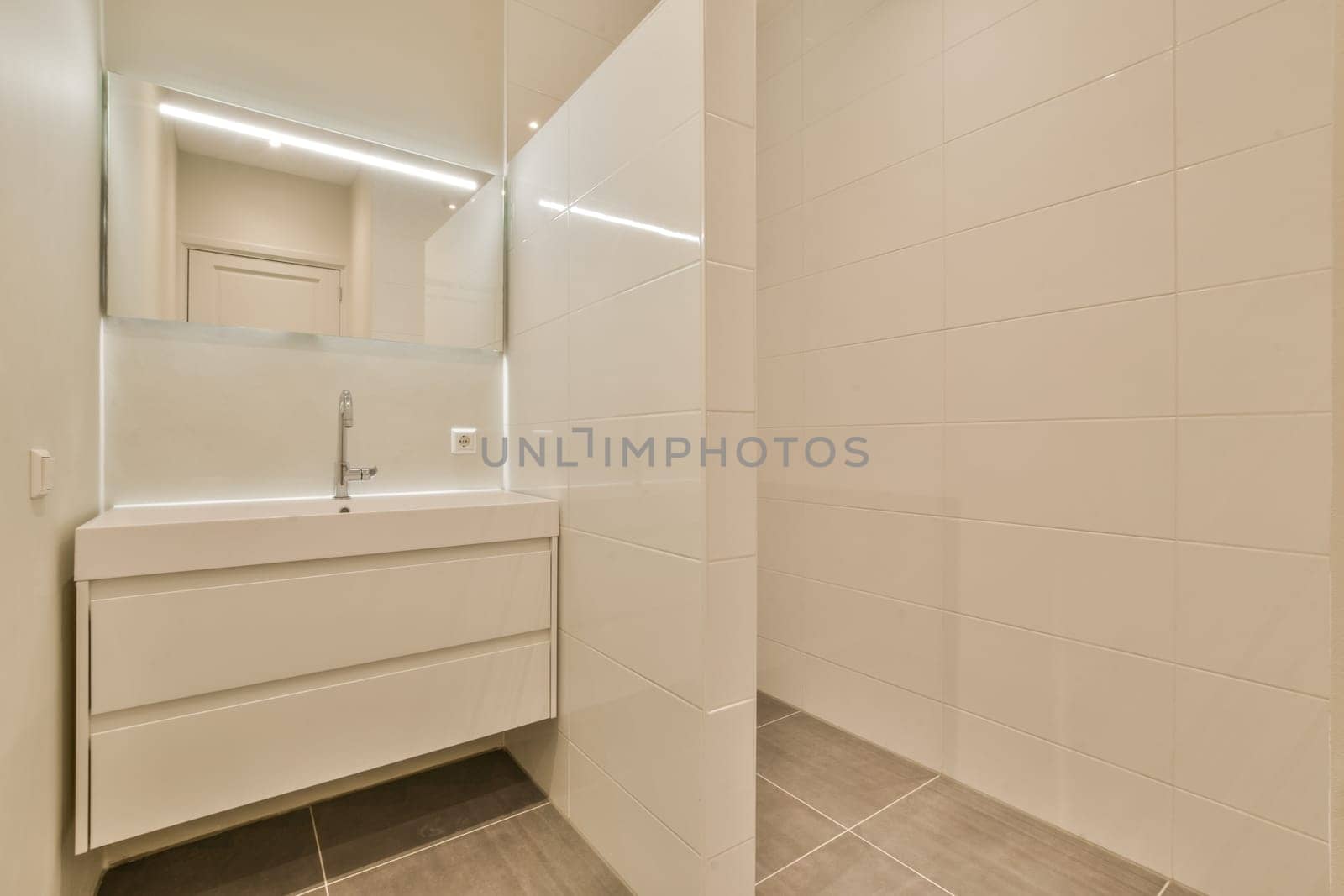 a white bathroom with tile flooring and wall mounted mirror above the sink area in the room is very clean