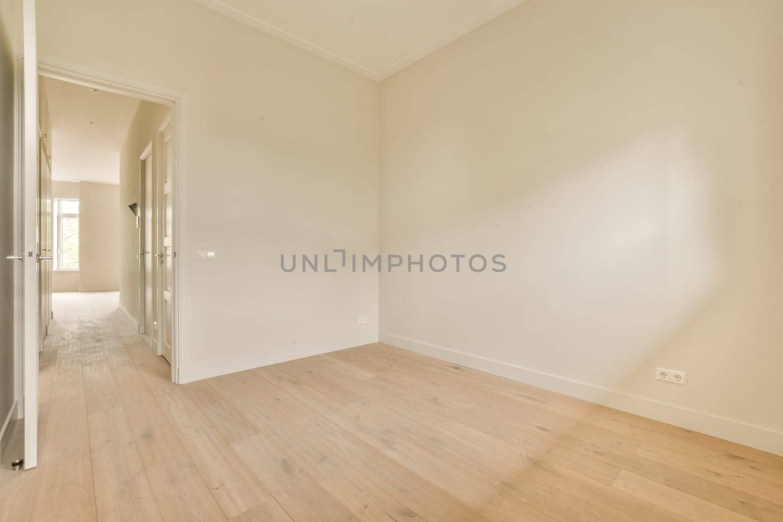 a living room with white walls and a wooden floor by casamedia