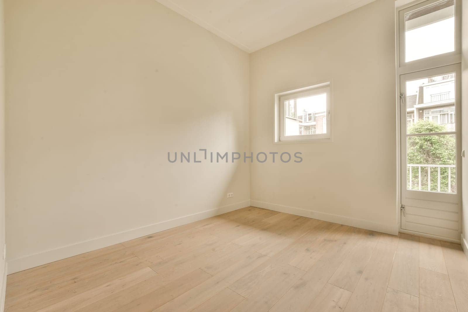 a living room with white walls and a window and by casamedia