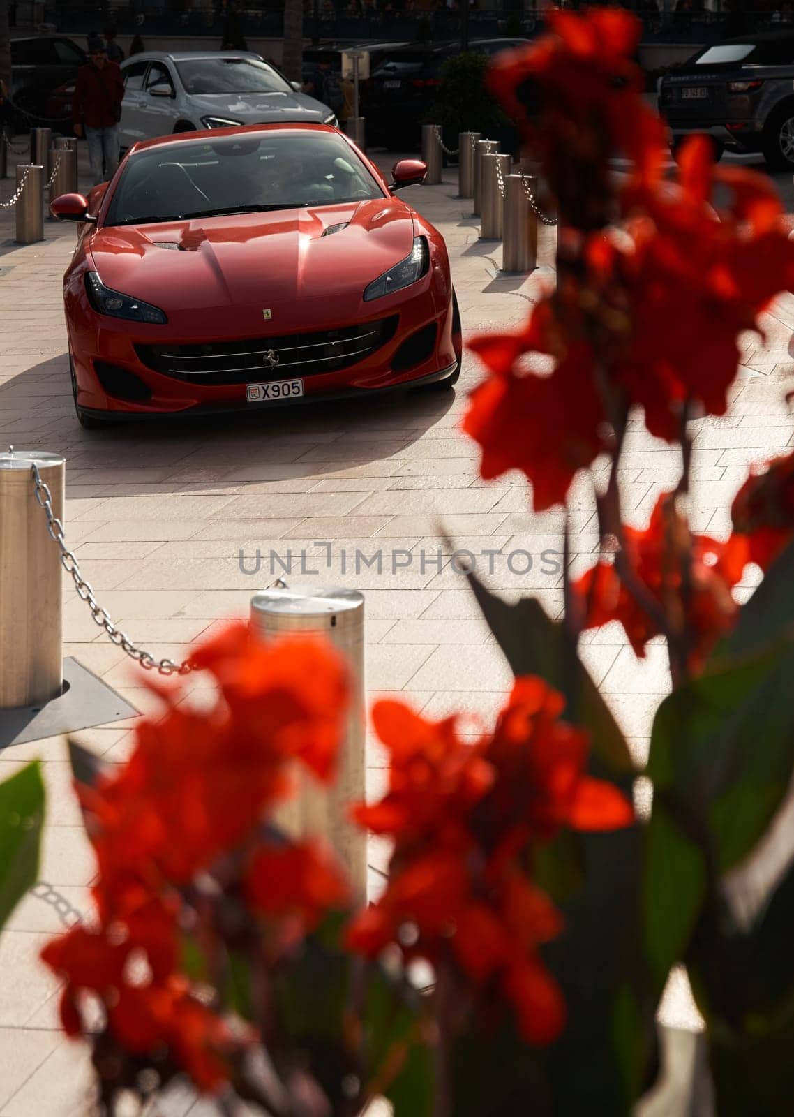 Monaco, Monte-Carlo, 22 October 2022: Square Casino Monte-Carlo at sunset, luxury cars, famous Hotel de Paris, wealth life, tourists take pictures of the landmark, pine trees, flowers. High quality photo