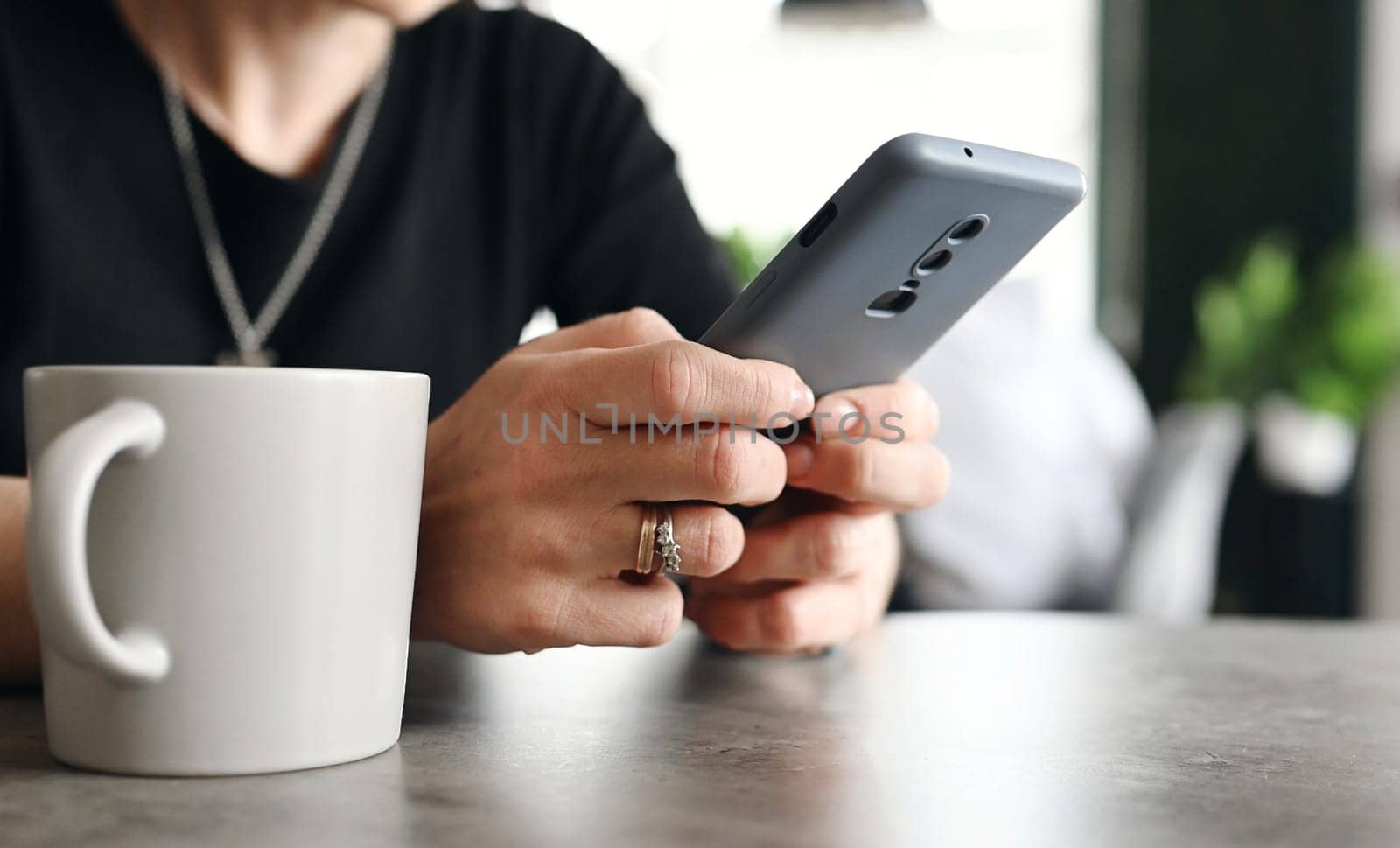 Girl Using A Smartphone For A Work On The Internet And A Social Medias In The Cafe