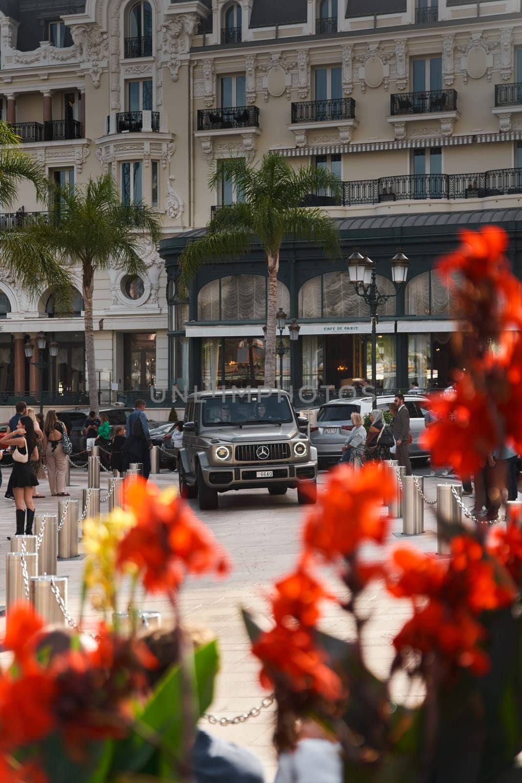 Monaco, Monte-Carlo, 22 October 2022: Square Casino Monte-Carlo at sunset, luxury cars, famous Hotel de Paris, wealth life, tourists take pictures of the landmark, pine trees, flowers. High quality photo